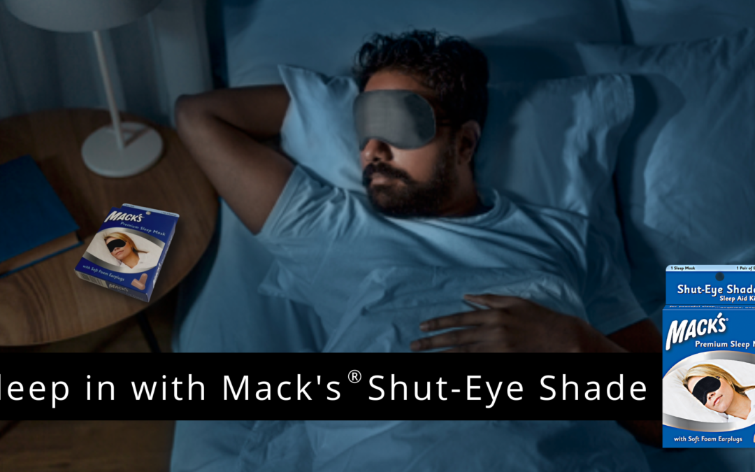 Man sleeping well using Mack's Shut-Eye Shade Premium Contoured Sleep Mask and a blue Mack's ear plugs package on night stand