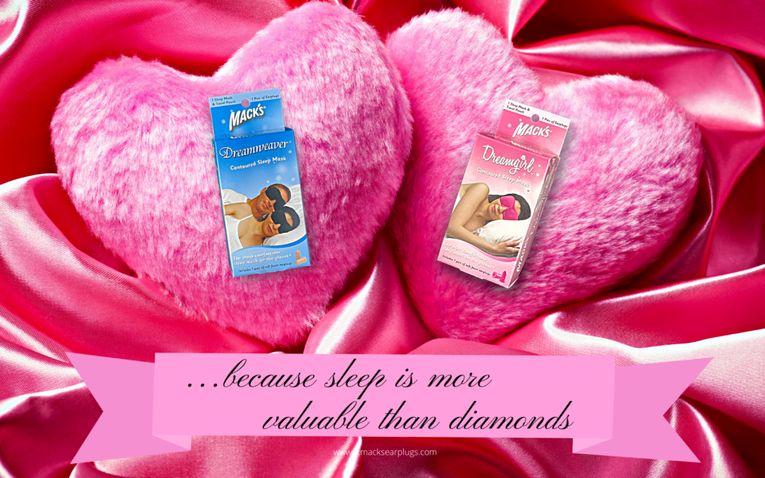 Dreamgirl and Dreamweaver Sleep Mask packages from Mack's earplugs sitting on two fluffy heart pillows for Valentine's day