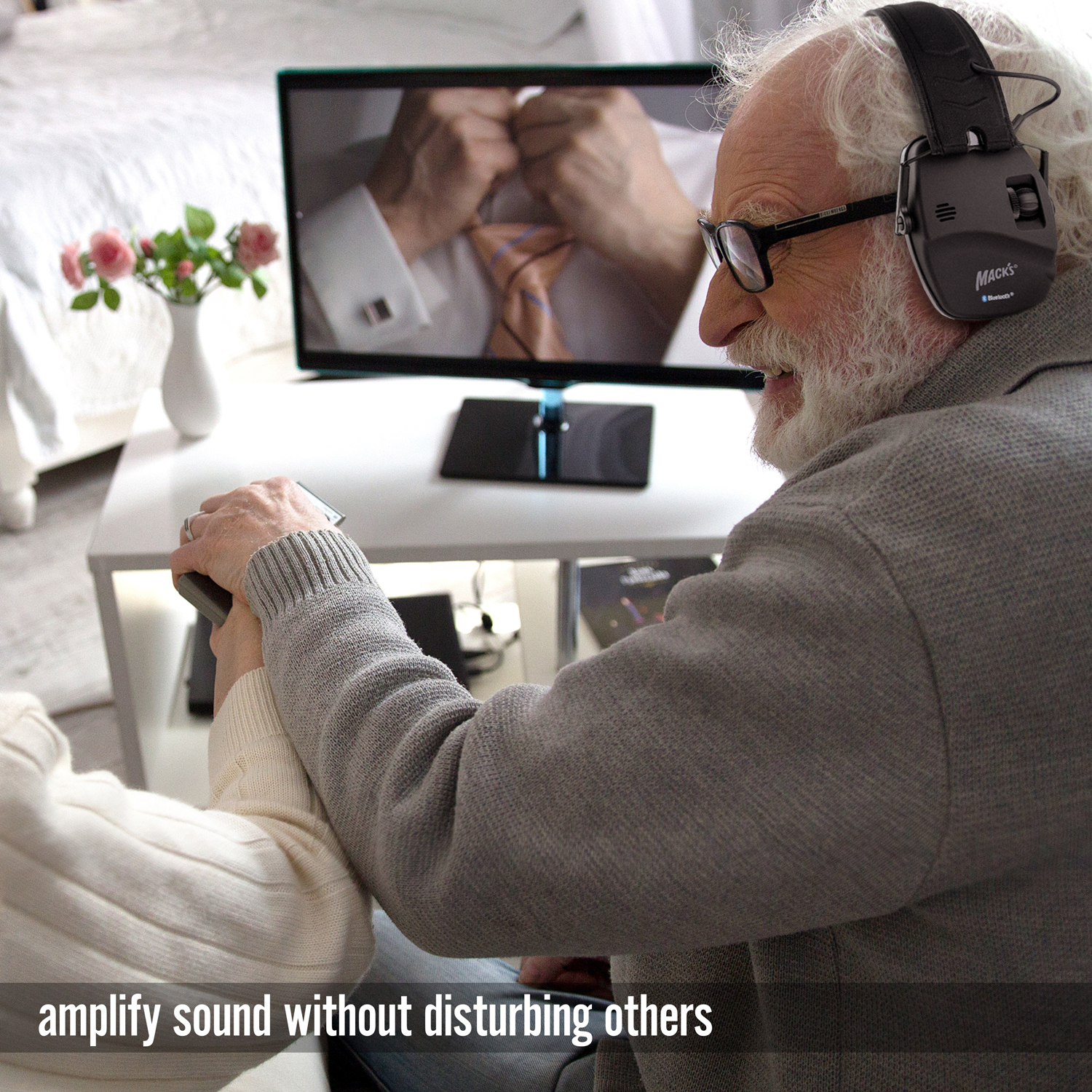 A older man wearing Mack's Electronic Hearing Muffs with Bluetooth compatibility