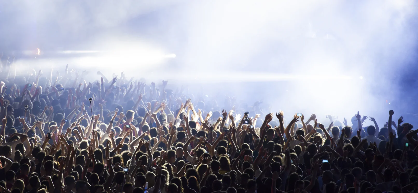 a crowd cheering and dancing at a concert