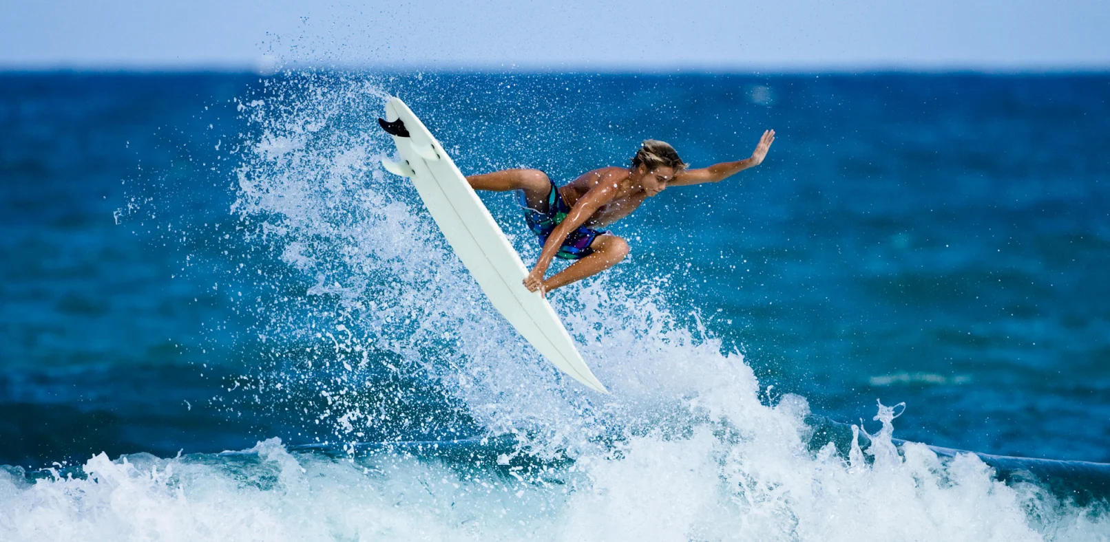 A person surfing wearing Mack's Earplugs